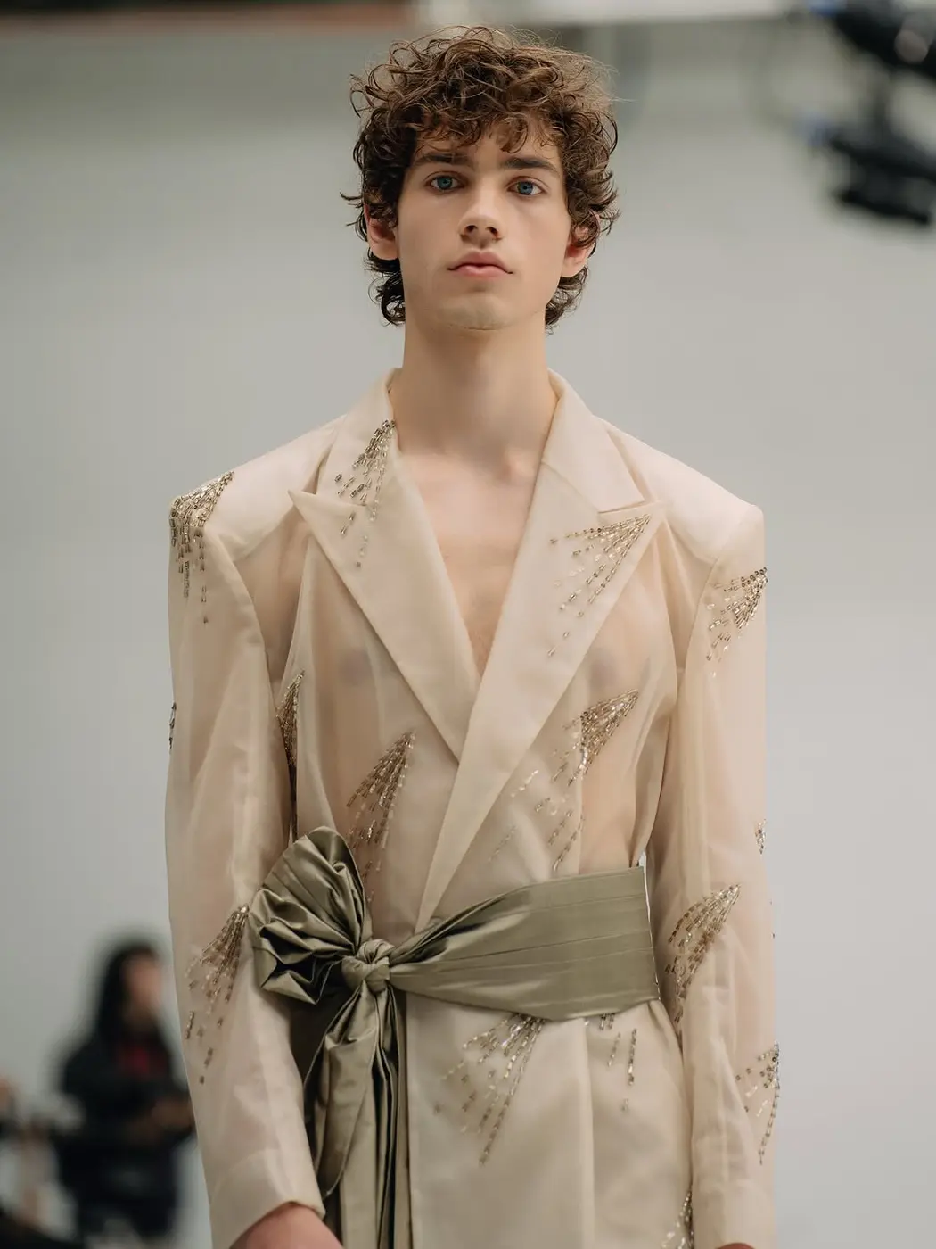 A male model in a cream wrapped suit