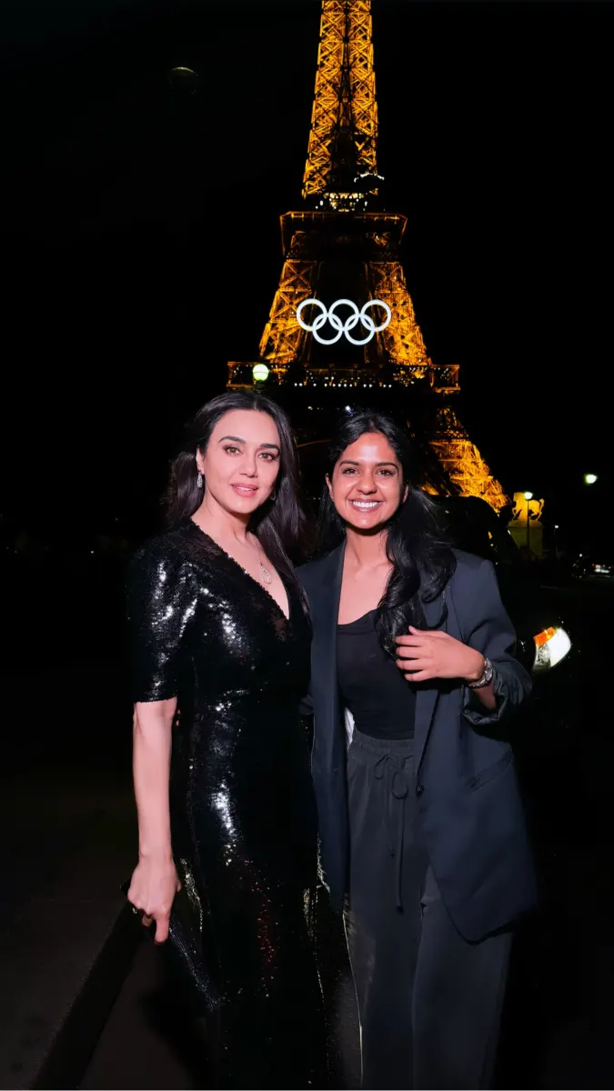 Shailza Swami with a guest in a sequinned gown in front of the Eiffel Tower